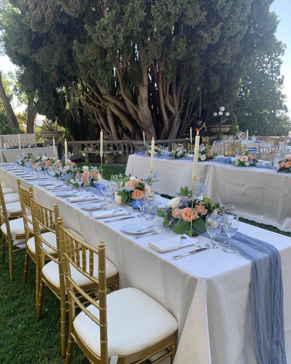 Garden reception tables with pastel florals and gold chairs